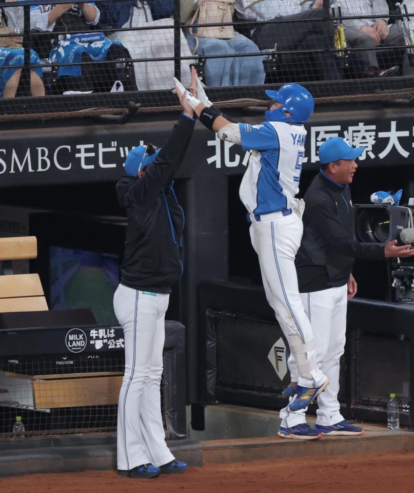 ４回、勝ち越し２ランを放ち、新庄監督（左）とハイタッチする山県（撮影・西岡正）