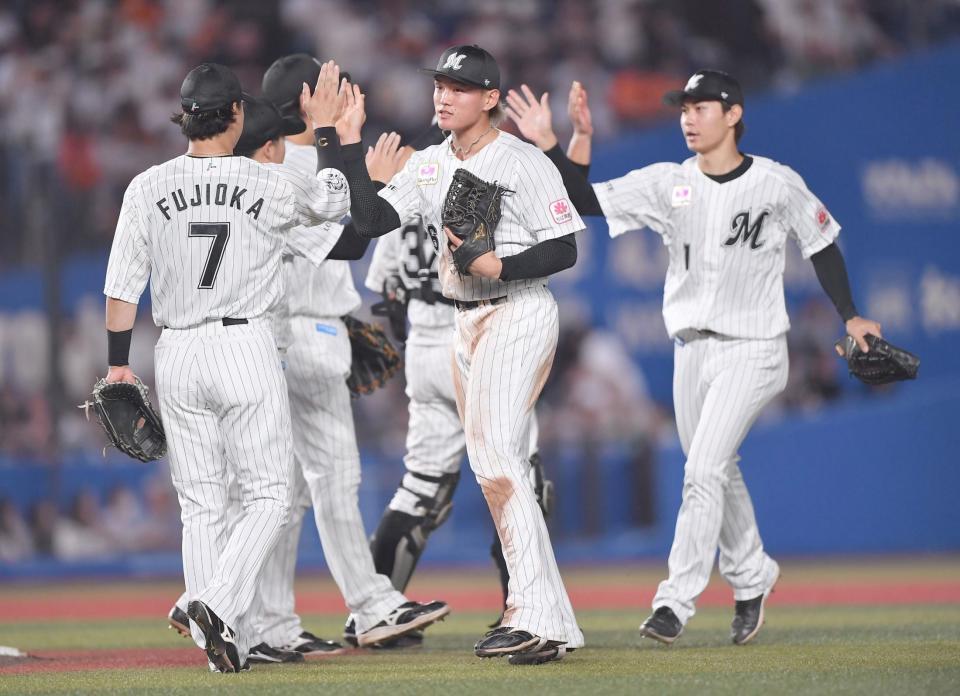 　巨人の追撃を振り切りタッチを交わす山本（中央）らロッテナイン（撮影・開出牧）