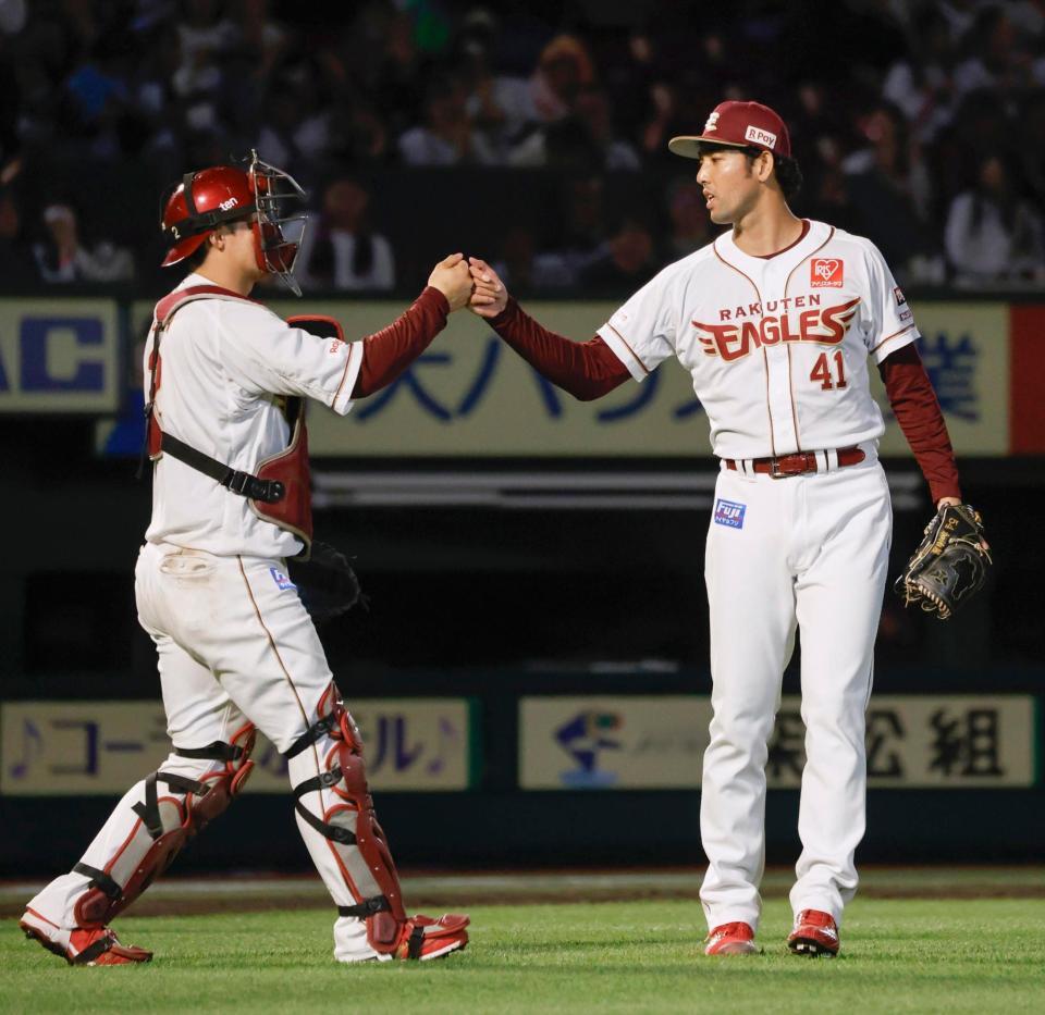 　９回のＤｅＮＡの反撃を断ち、捕手太田とタッチを交わす楽天・加治屋＝