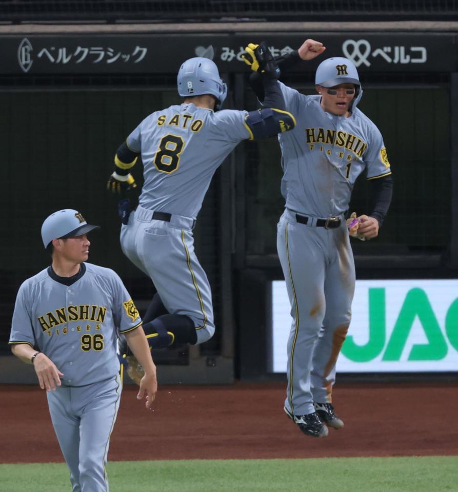 　８回、２ランを放ち、森下（右）とタッチを交わす佐藤輝（撮影・西岡正）