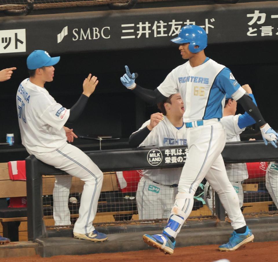 ２回、ソロを放ち、ナインとタッチを交わす万波（右）＝撮影・西岡正