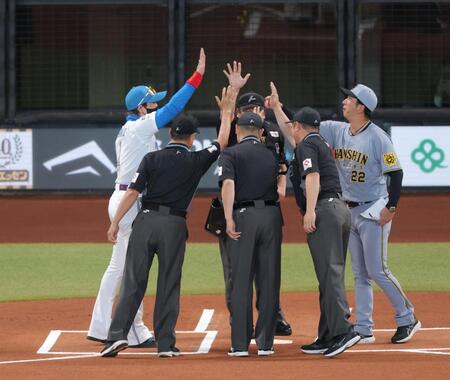 　メンバー表交換で新庄監督（左）、審判団と手を合わせた後、上に上げる藤川監督（撮影・西岡正）