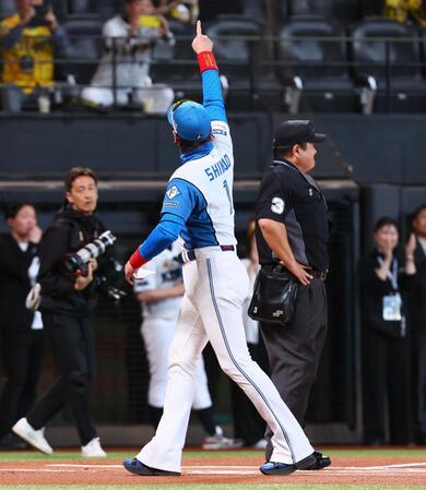 　藤川監督とのメンバー表交換を終え、スタンドを指さす新庄監督（撮影・中島達哉）