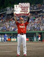 　２千試合出場を達成し、記念のボードを掲げる浅村