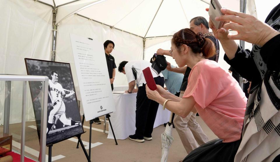 　記帳所で長嶋茂雄さんの写真にカメラを向ける人たち