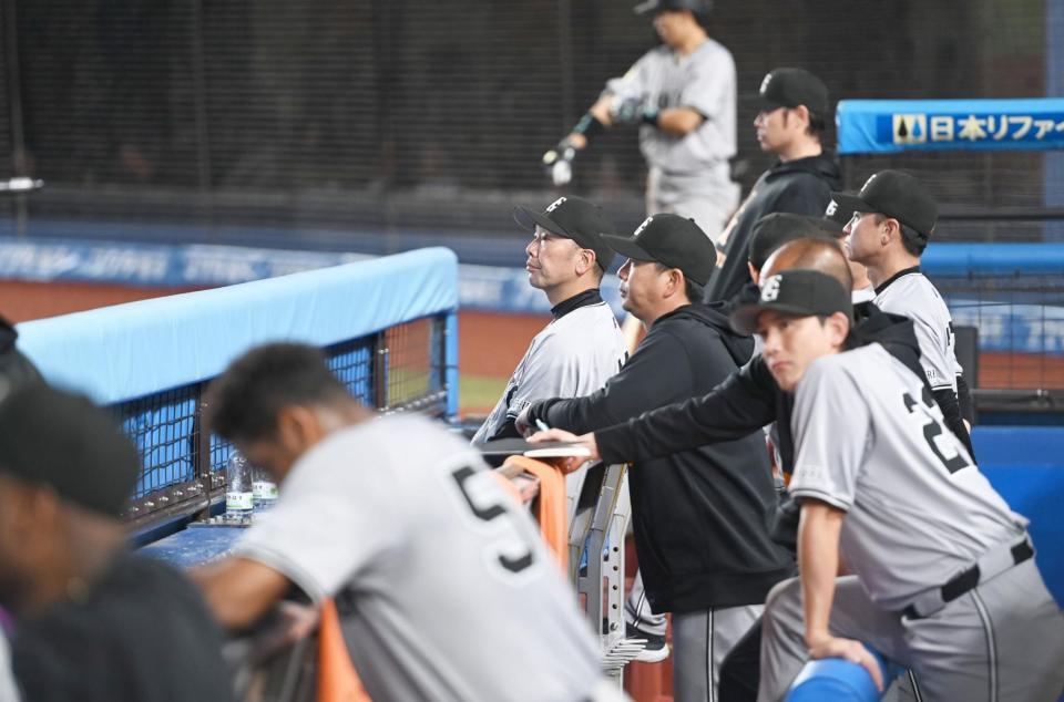 　延長戦に入りベンチで戦況を見守る阿部監督（後方左）＝撮影・開出牧