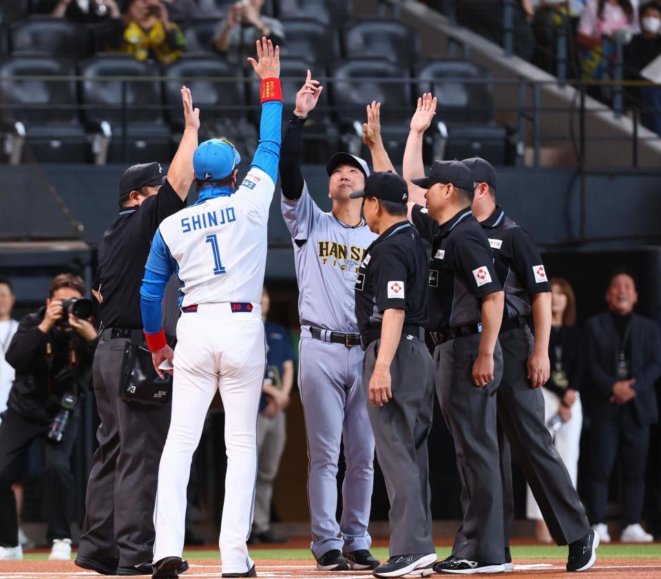 　メンバー表を交換し、新庄監督（左から２人目）、審判団と手を挙げる藤川監督（中央）＝撮影・中島達哉