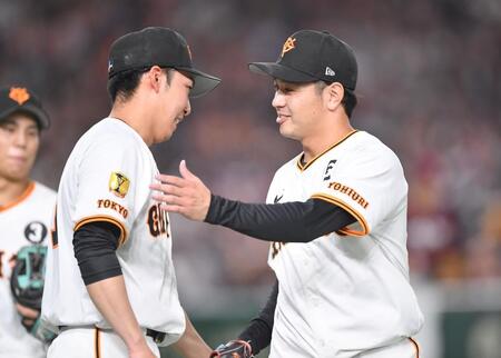 　７回、代打・フランコを三振に仕留め、赤星（左）とタッチを交わす石川（撮影・開出牧）