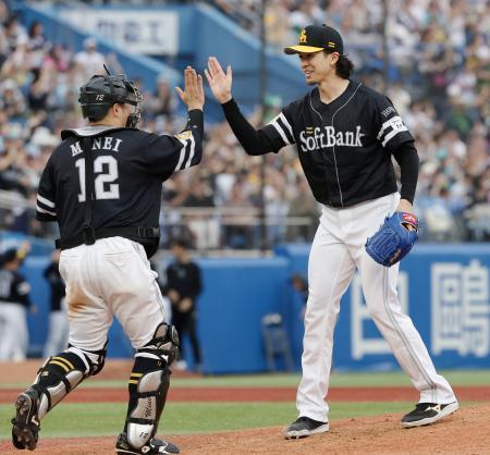 　完投で４勝目を挙げ、捕手嶺井とタッチを交わすソフトバンク・上沢＝神宮