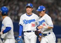 　７回を投げ終え、笑顔でベンチに戻る松葉。右は大島