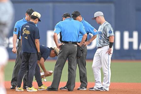 １回表終了後、二塁ベースを確認する審判ら（撮影・飯室逸平）