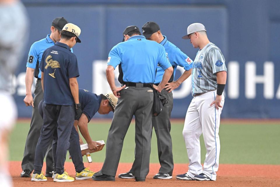 １回表終了後、二塁ベースを確認する審判ら（撮影・飯室逸平）