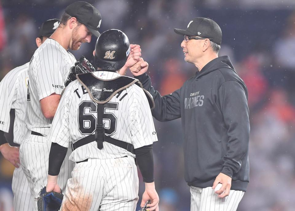 ８回、投手交代を告げた吉井監督（右）は、好投した先発・サモンズとグータッチを交わす（撮影・開出牧）