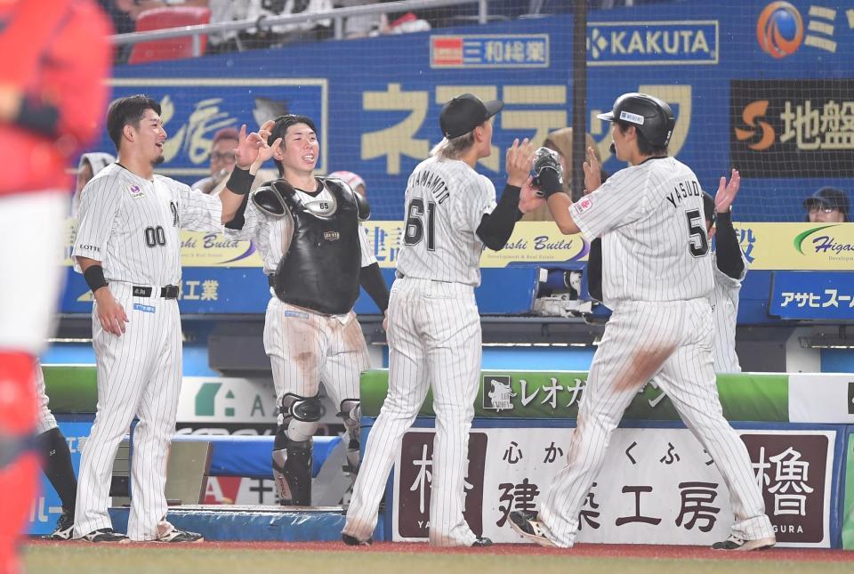 ６回、生還しナインとタッチを交わす安田（５）＝撮影・開出牧