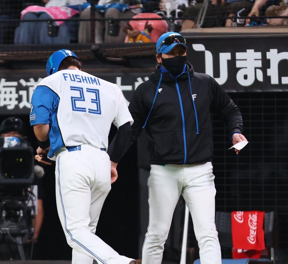 ６回、適時二塁打を放った伏見（左）を迎える新庄監督（撮影・中島達哉）