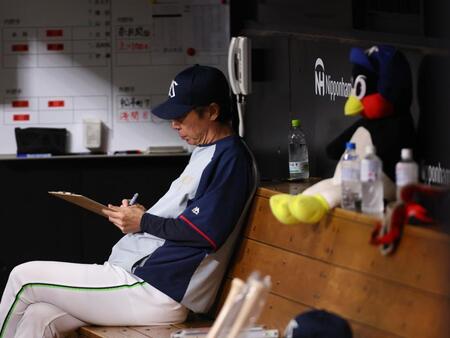 　５回、何か書き込む高津監督（右はつば九郎のぬいぐるみ）＝撮影・中島達哉