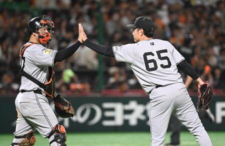 　ソフトバンクに快勝し、９回に３番手で登板した石川（右）は岸田とタッチする　