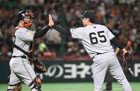 　ソフトバンクに快勝し、９回に３番手で登板した石川（右）は岸田とタッチする　