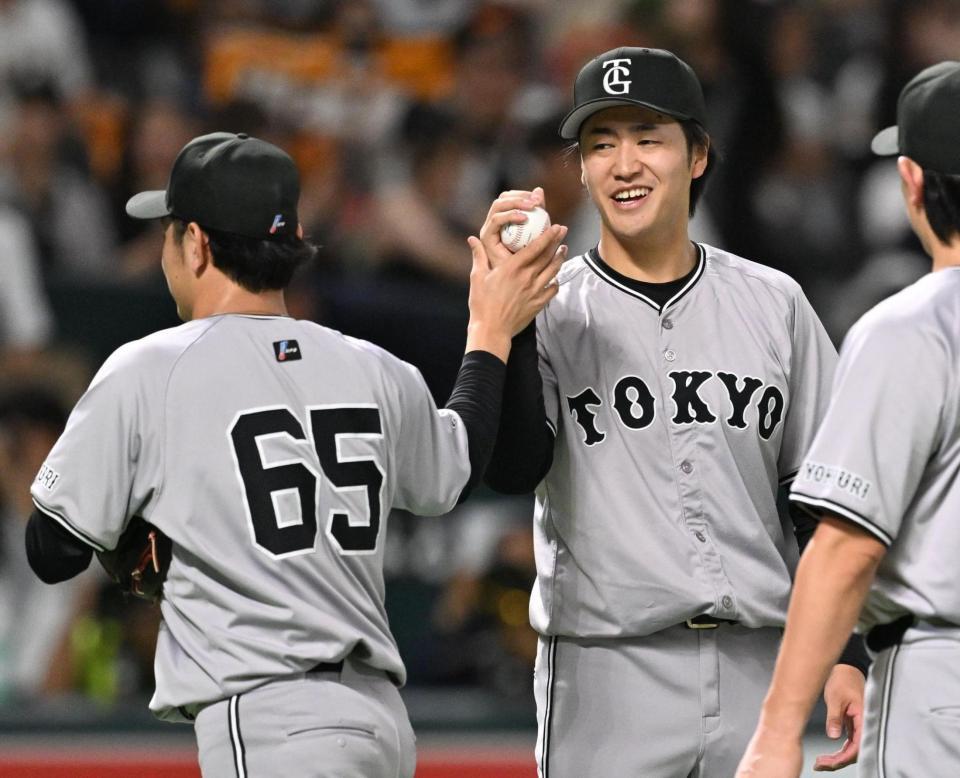 　今季初勝利を挙げ、石川（左）からウイニングボールを受け取る西舘