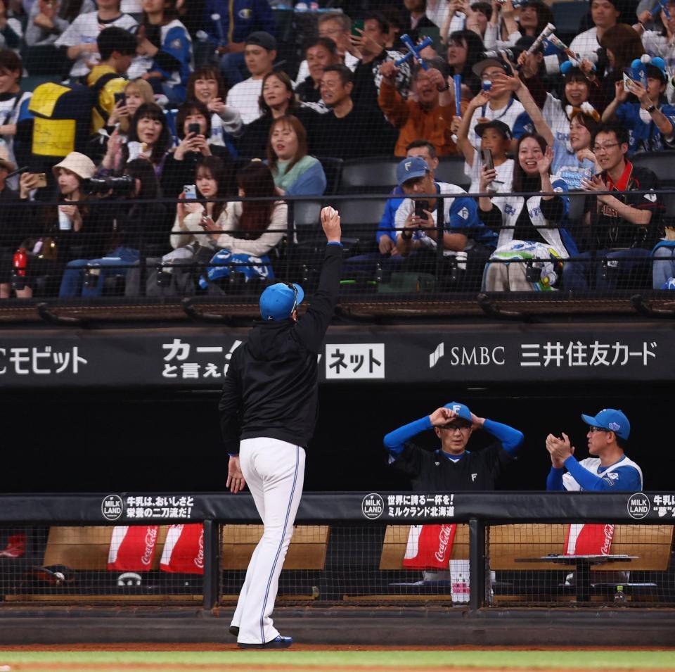 　７回、進藤のプロ初安打の記念球をスタンドのファンに掲げる新庄監督（撮影・中島達哉）