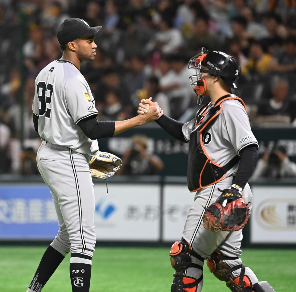 　１２回裏に登板し、無失点に抑えたマルティネス（左）は岸田とタッチする
