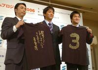 　長嶋会長直筆のＴシャツを手に笑顔を見せる（左から）宮本代表幹事、長嶋一茂総括ディレクター、高橋副幹事＝２００５年１１月