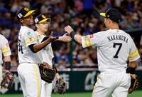 　今季初完投で６勝目を挙げ、中村（７）からウイニングボールを受け取るモイネロ