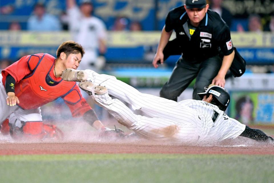 　７回、坂倉（左）のタッチをかわし、藤原が勝ち越しの生還