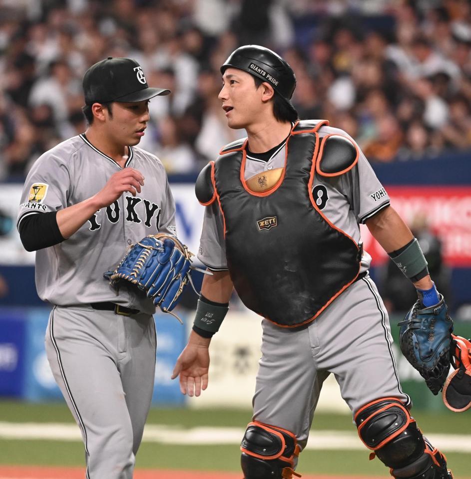 　５回裏から守備に就き、赤星（左）に声を掛けながらベンチに戻る小林