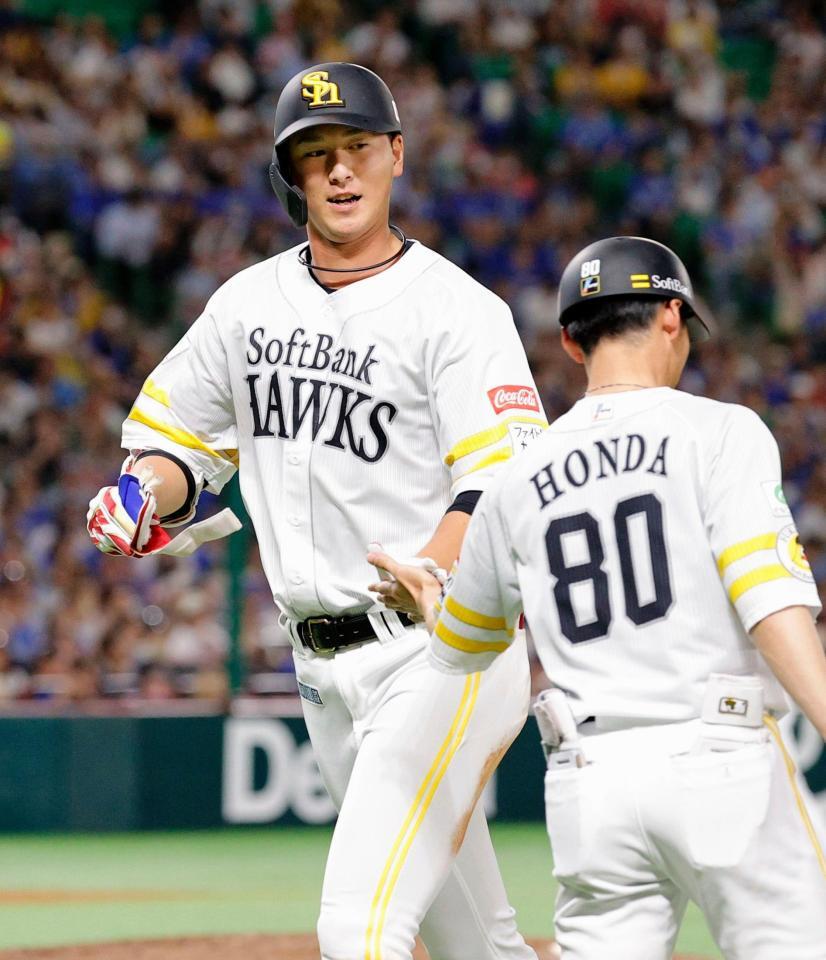 　４回、先制の２点打を放ち、コーチとタッチしてベンチに戻る秋広