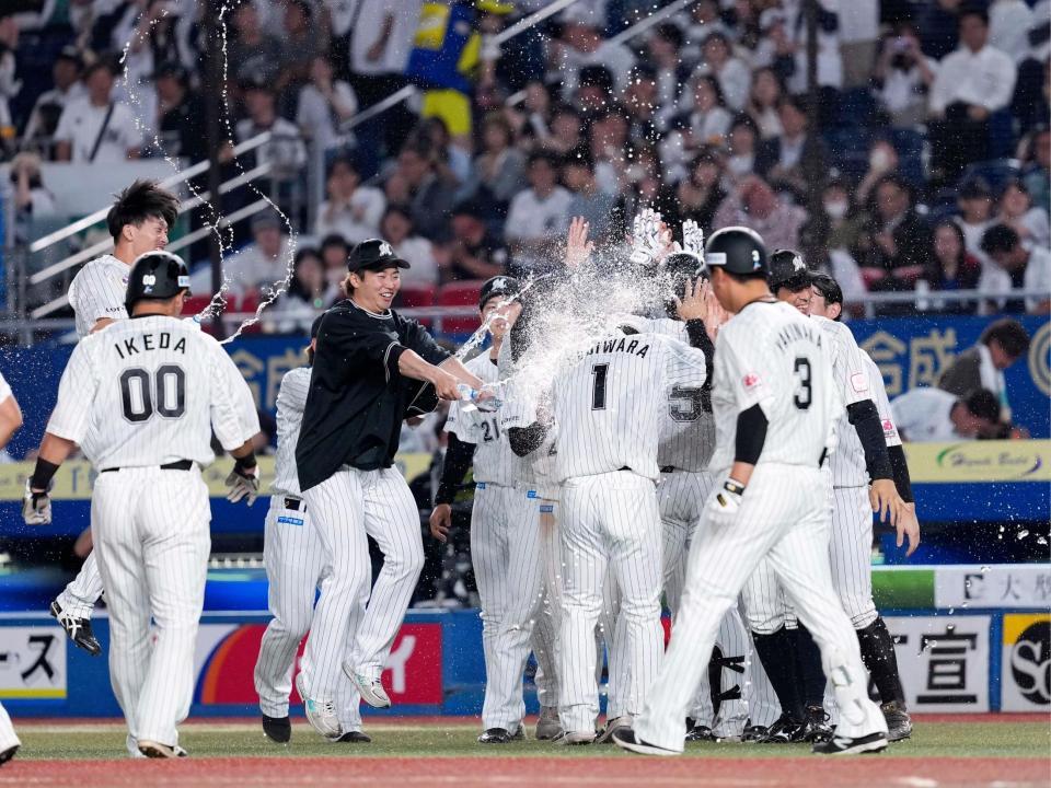 　９回、大西の暴投で三走藤原（１）がサヨナラの生還を果たし、手荒い祝福をするロッテナイン