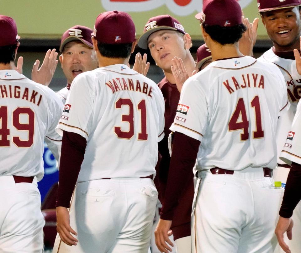 　阪神に勝利し、三木監督（左）らとナインを迎えるハワード（中央）。５回２失点で３勝目を挙げた