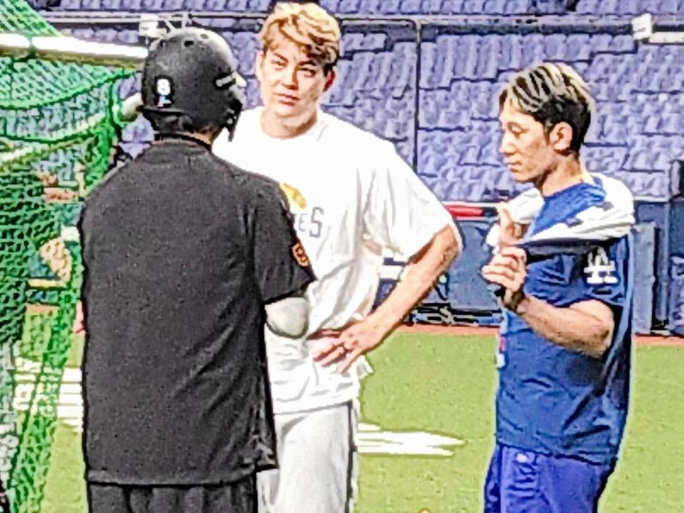 　広島時代の同僚、丸と談笑する九里（中央）と西川（右）