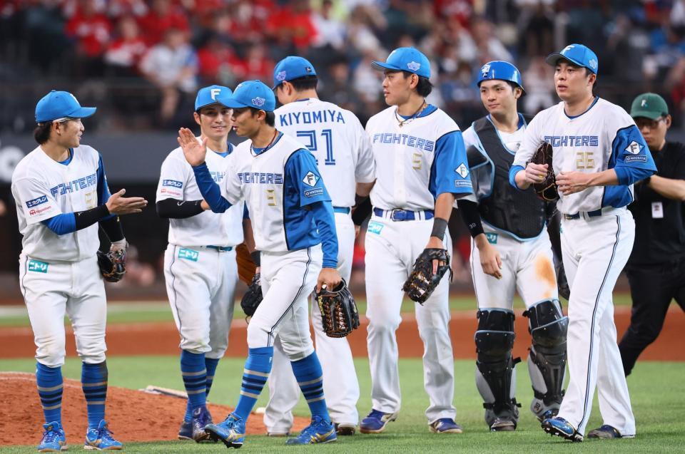 　広島に勝利をあげ、タッチを交わす日本ハムナイン（撮影・中島達哉）