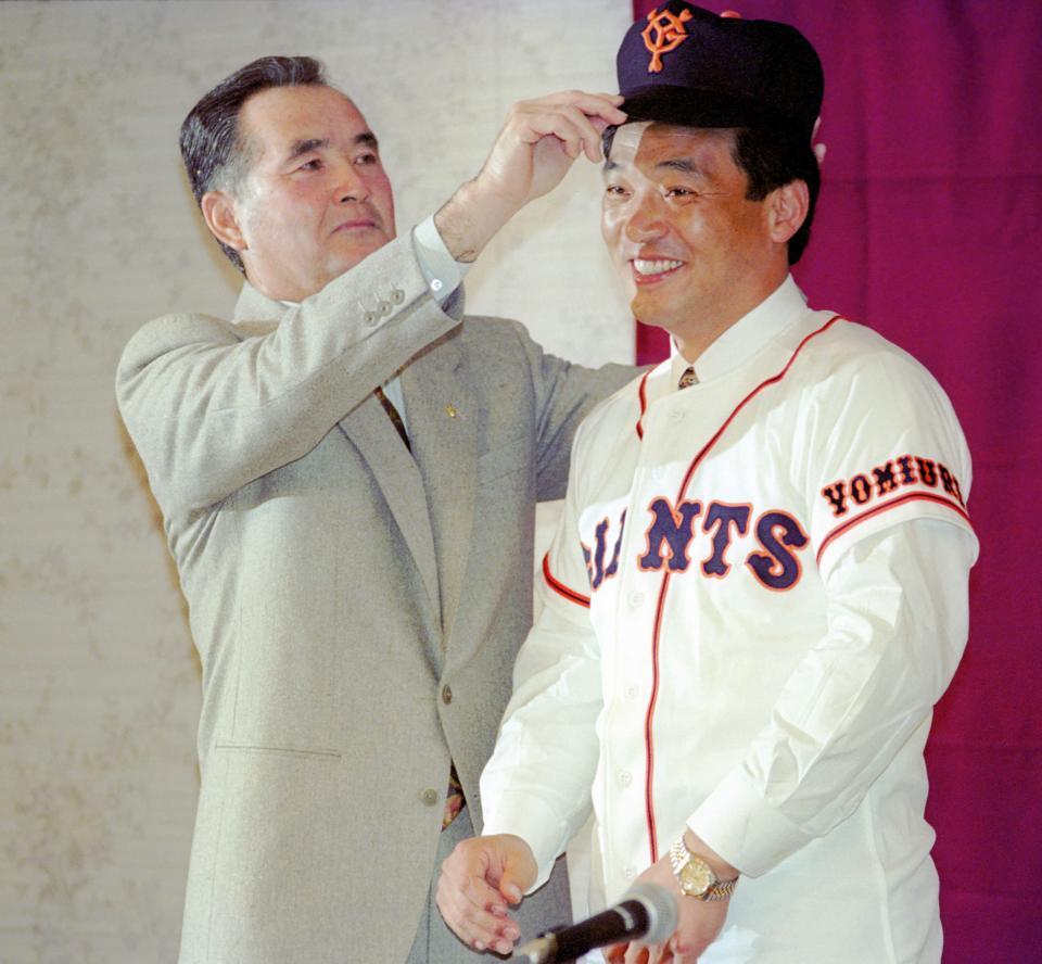 　巨人入団会見で当時の長嶋監督から帽子をかぶせてもらう落合博満氏=１９９３年１２月