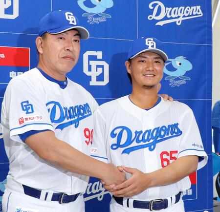 　西武から金銭トレードで中日に加入し、井上監督（左）と握手する佐藤