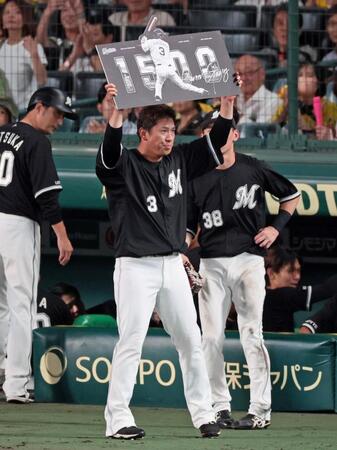 　１５００試合出場を達成し記念ボードを掲げる角中（撮影・立川洋一郎）