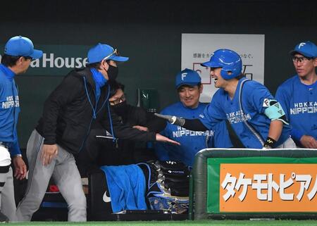 　２回、左越えソロを放った伏見（右手前）とタッチを交わす新庄監督（撮影・開出牧）