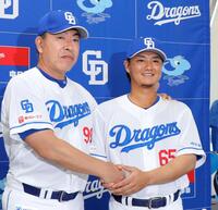 　西武から金銭トレードで中日に加入し、井上監督（左）と握手する佐藤