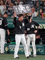 　１５００試合出場を達成し記念ボードを掲げる角中（撮影・立川洋一郎）