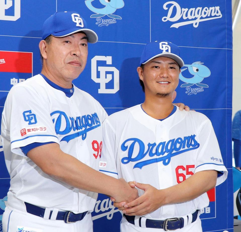 　西武から金銭トレードで中日に加入し、井上監督（左）と握手する佐藤
