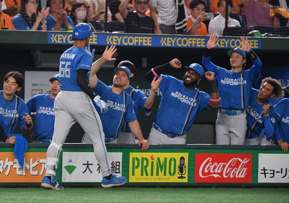 　２回、先制の右越え２ランを放ちナインとタッチを交わす万波（左手前）＝撮影・開出牧