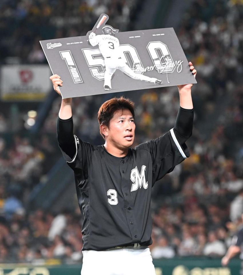 　１５００試合出場の記念ボードを掲げる角中（撮影・飯室逸平）