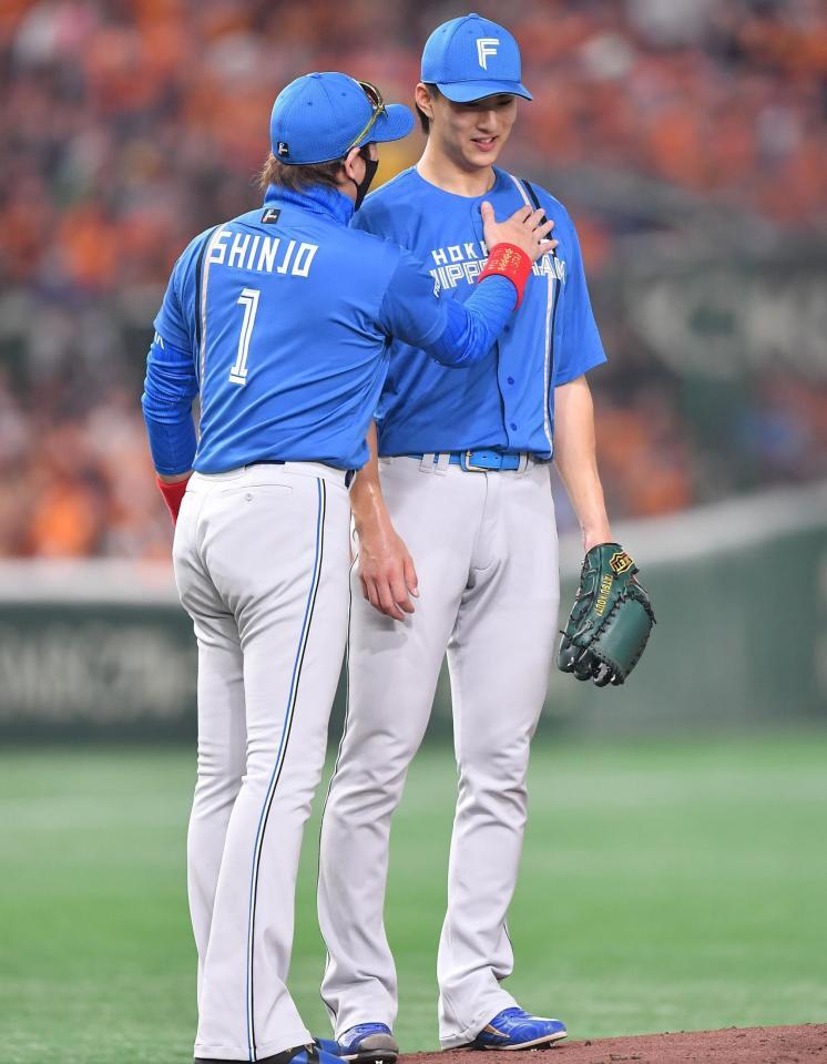 　７回、投手交代を告げた新庄監督（左）は好投の先発・達の胸を叩いて言葉をかける（撮影・開出牧）