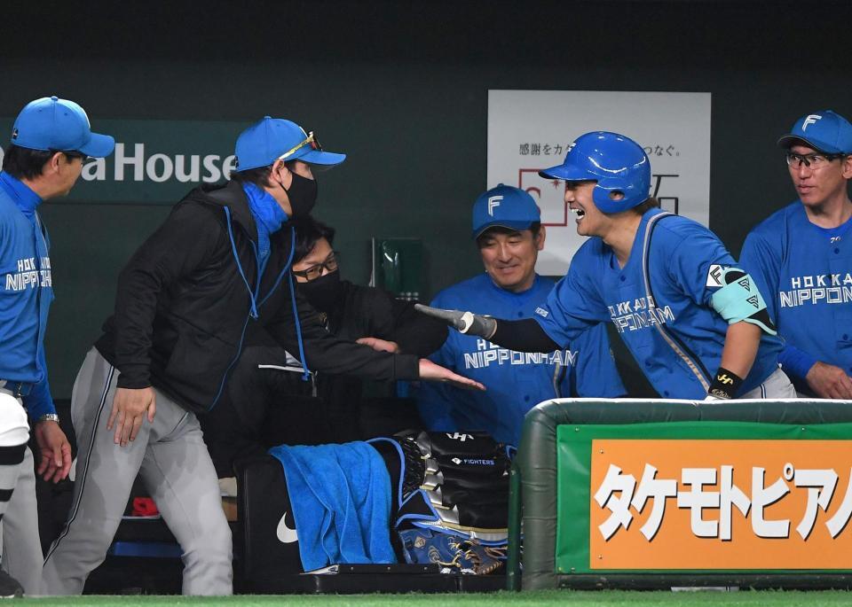 　２回、左越えソロを放った伏見（右手前）とタッチを交わす新庄監督（撮影・開出牧）