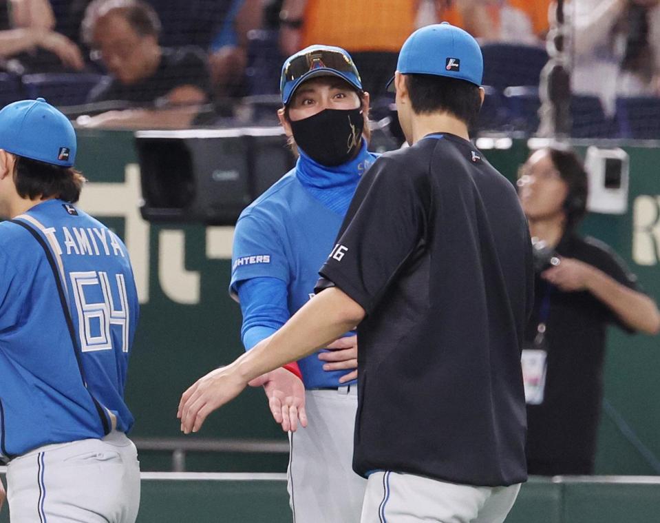 　巨人に勝利し、達（右）とタッチを交わす新庄監督