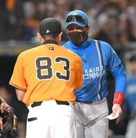 　試合前のメンバー表交換を終え、阿部監督（手前）と握手を交わす新庄監督（撮影・伊藤笙子）