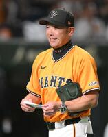 　試合前のメンバー表交換時に新庄監督から深緑の紙袋を受け取った阿部監督（撮影・伊藤笙子）