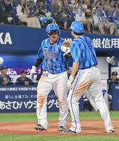 　５回、宮崎の適時二塁打で生還した牧（左）は佐野に迎えられる（撮影・持木克友）