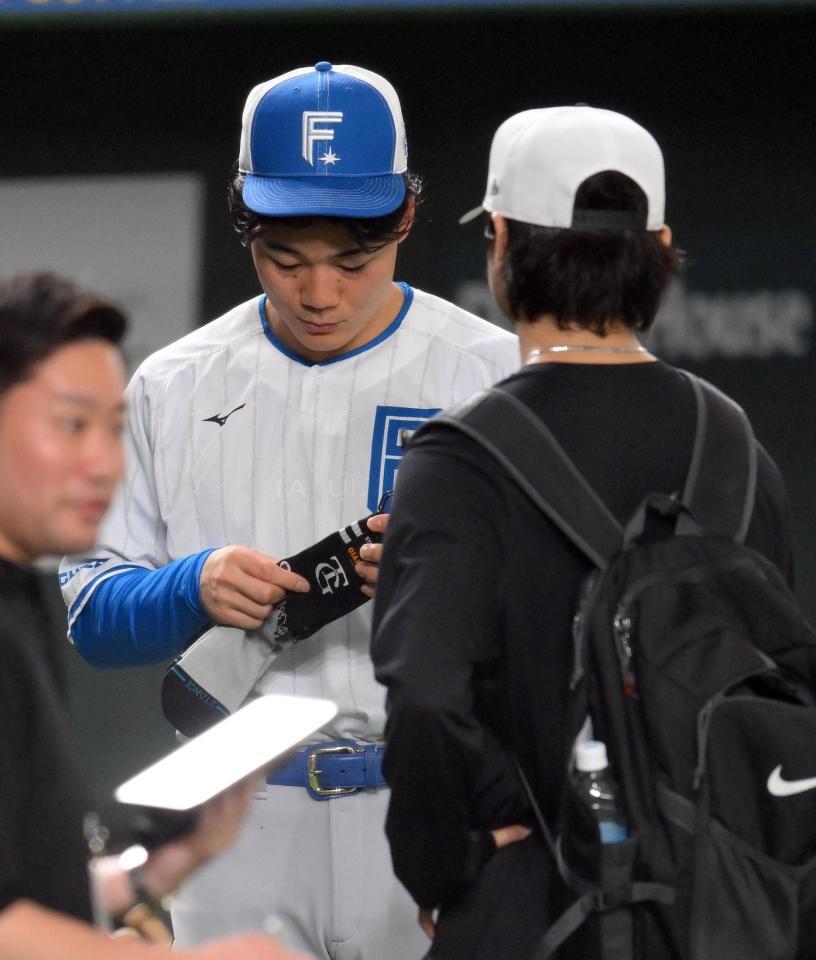 　試合前、田中瑛（右手前）から靴下をプレゼントされる清宮幸（撮影・伊藤笙子）